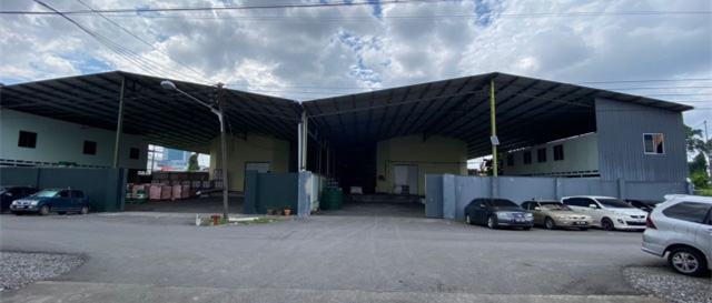 Open-fronted warehouse sheds with cars parked in front