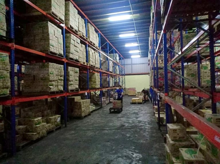 An aisle between tall racking of stock in the Hua Ban Group warehouse in Sibu.
